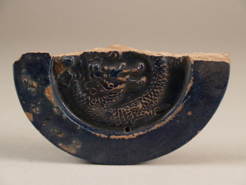 Scherf van nokdakpan met reliëf van draak en bedekt met diep paars-blauw glazuur